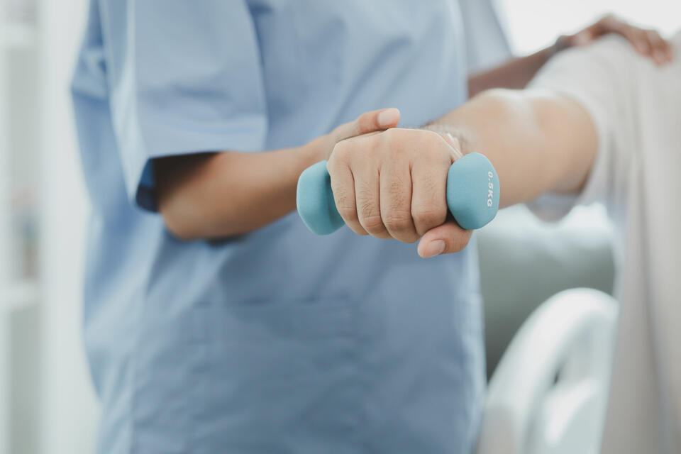 A person doing exercises being helped by a nurse